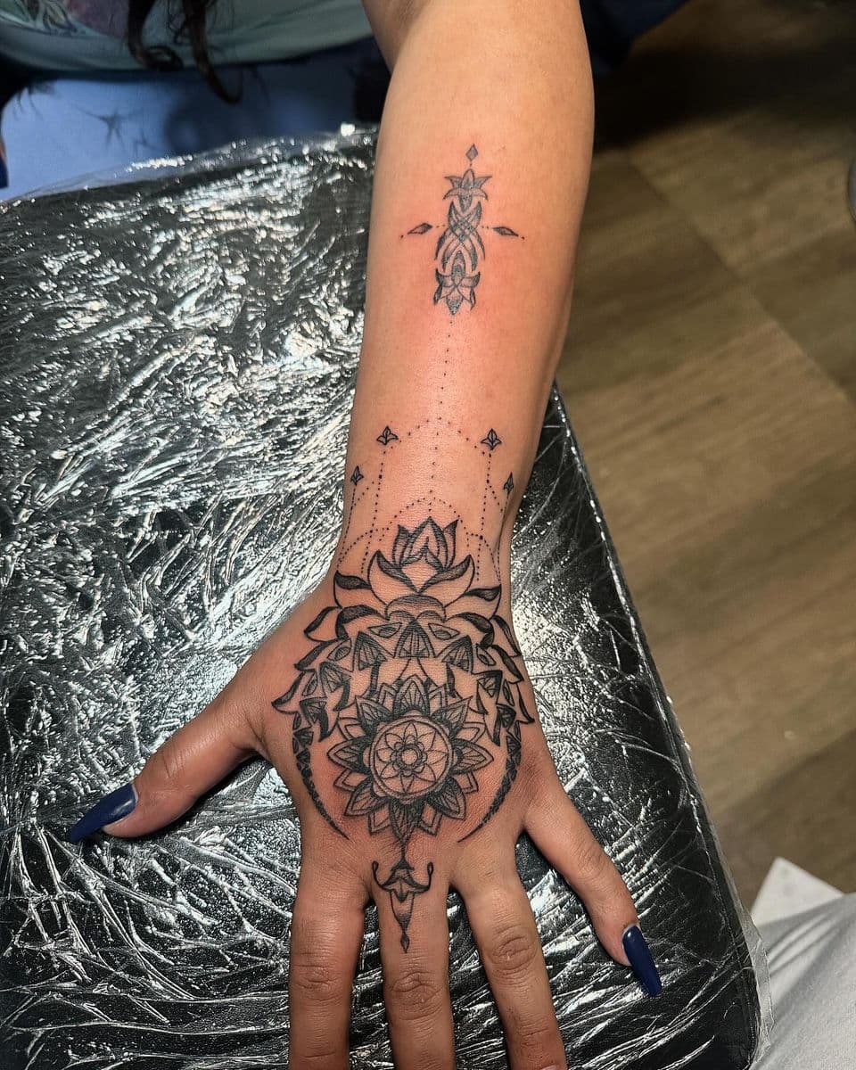 Geometric mandala blackwork across hand and forearm