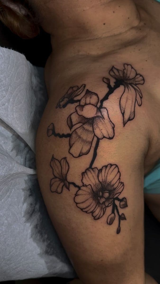 Fine line orchid branch flowers on shoulder