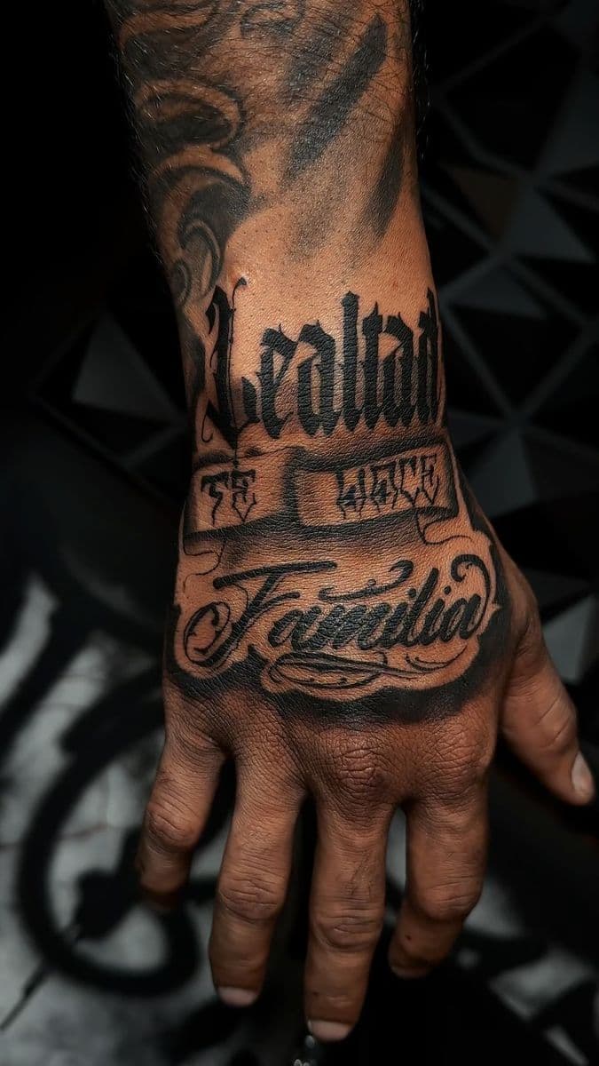 Lealtad Familia chicano script lettering across the hand