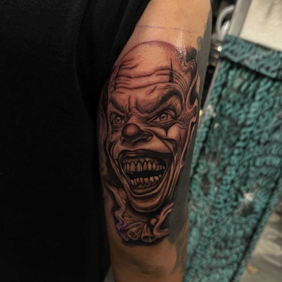 Evil clown face black and grey realism on forearm